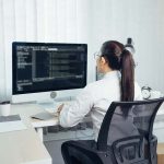 Asian woman professional development programming website working a software in office room.