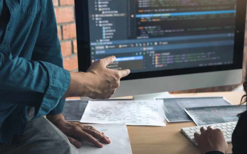 Developing programming and coding technologies working in a software engineers developing applications together in office.