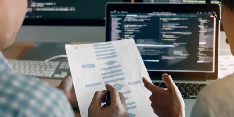 Developing programming and coding technologies working in a software engineers developing applications together in office.