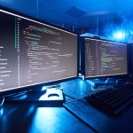 Image of computer monitors updating the software they standing on the table in dark room
