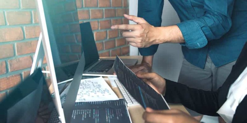 Developing programming and coding technologies working in a software engineers developing applications together in office.